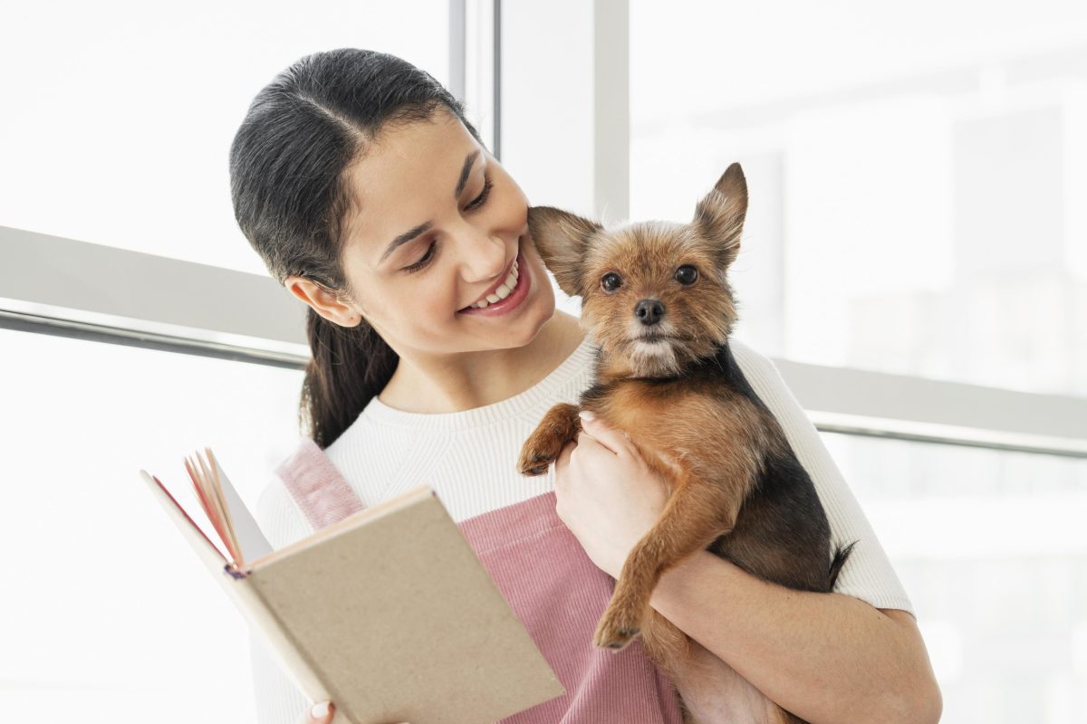 medium-shot-girl-holding-dog-book